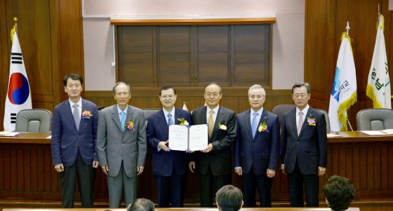 北韩大学院大学校长宋旻淳（左四）将名誉硕座教授学位证书转交给池田SGI副会长（右四）
